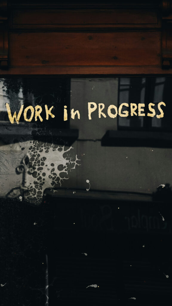 glasdør med sætningen, "work in progress" skrevet med gul